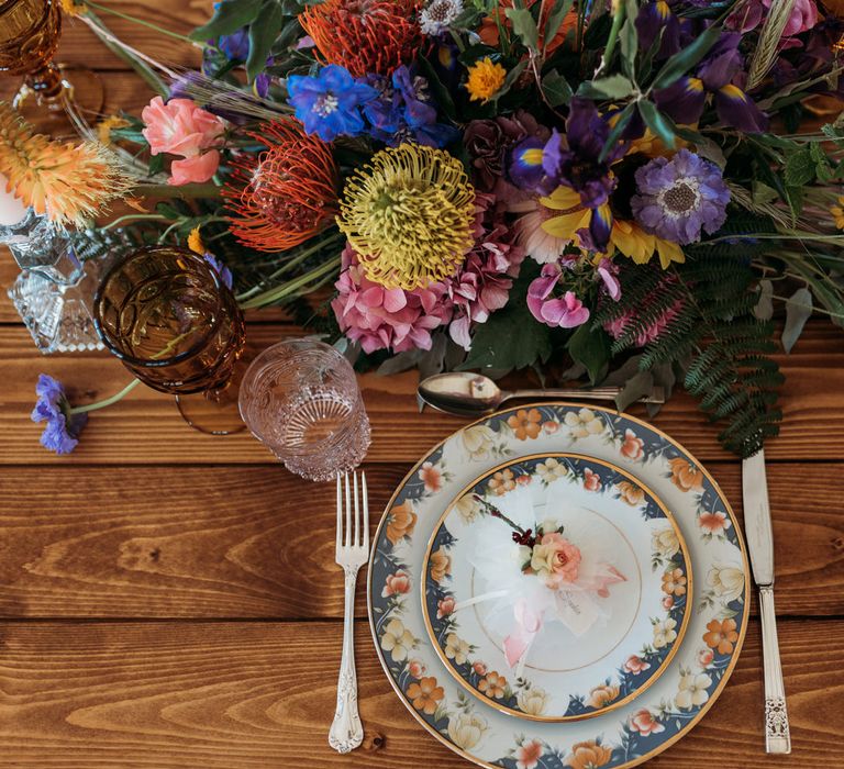 Place setting with patterned china and floral centrepiece 