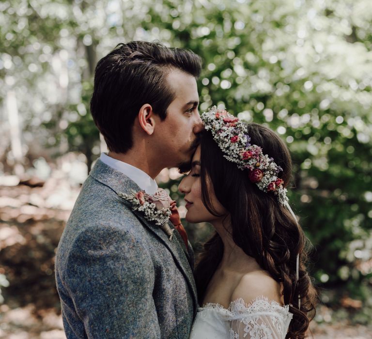 Groom kisses bride on forehead