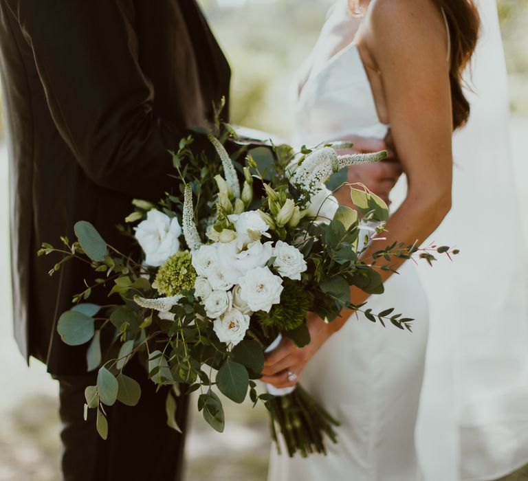 Bride holding a white flower bouquet for minimal Mexico wedding