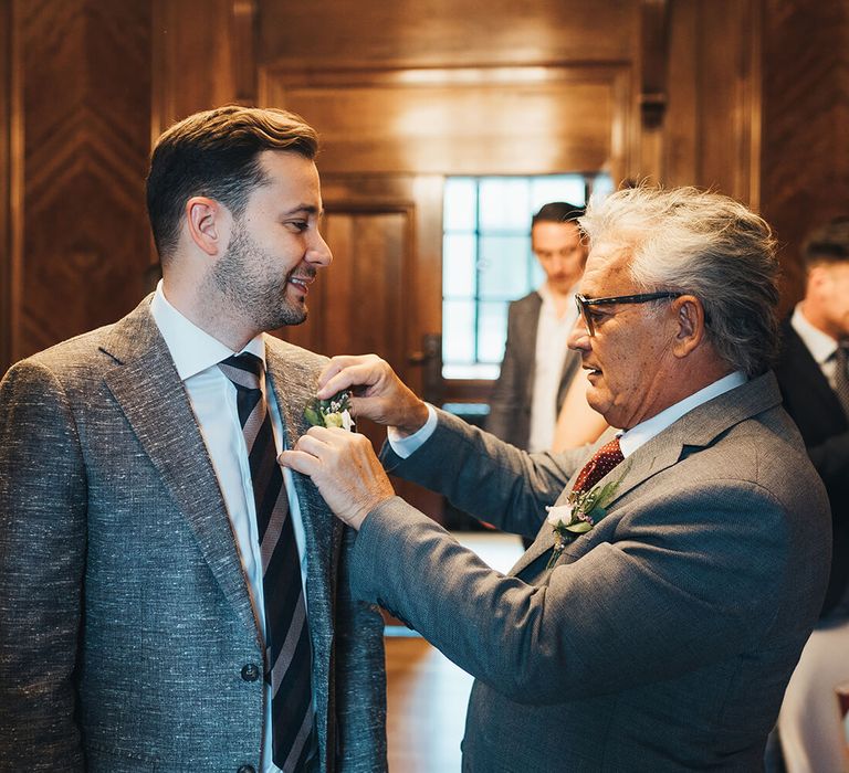 Father of the groom arranging the grooms buttonhole flower 