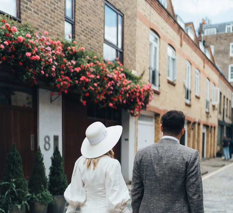 Bride and groom walking away from camera with bride wearing short wedding dress