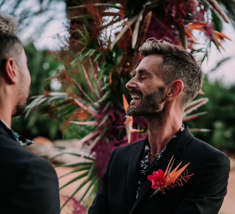 Groom in black suits laughs at ceremony at drag race wedding inspiration shoot. Photography by Stephanie Shenton.