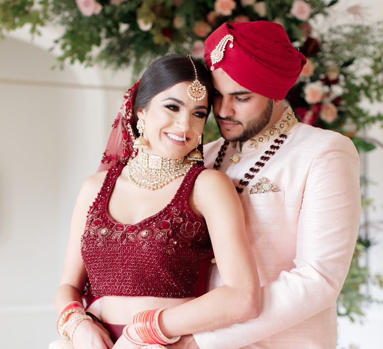 Groom wraps arms around brides waist 