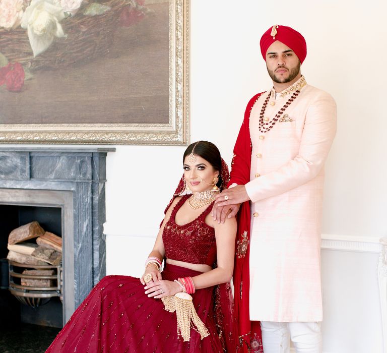 Bride sits whilst groom places his hand on her shoulder