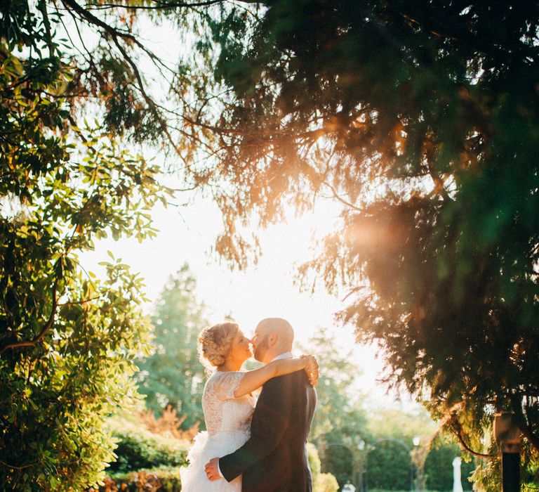 The bride and groom share a kiss in the afternoon sun in the grounds of Tenuta Pegazzera