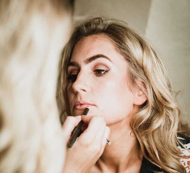 Bride has her makeup applied on the morning of her wedding