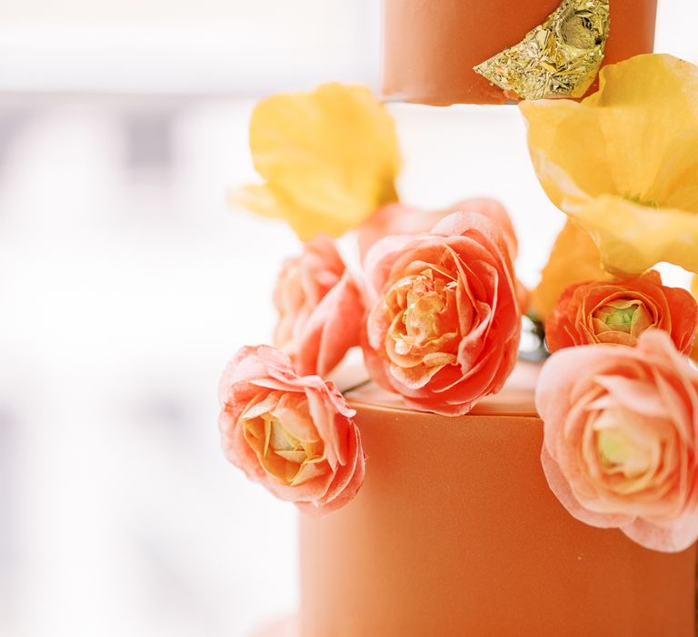 Orange wedding cake with floral decor