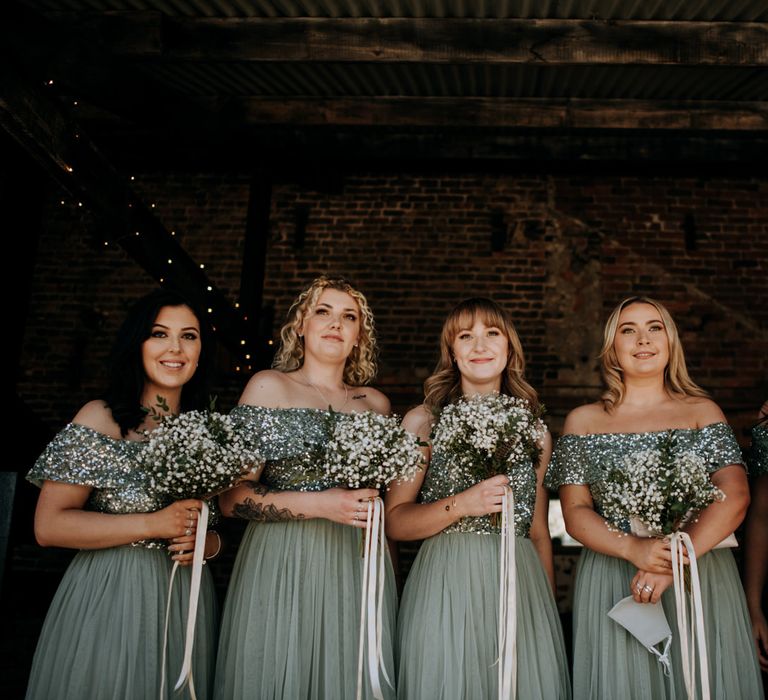 Bridesmaids in sage green chiffon and sequin dresses from ASOS 