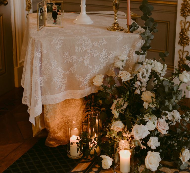 Two tier wedding cake sits upon white tablecloth in white and gold gilded room at the Markree Castle