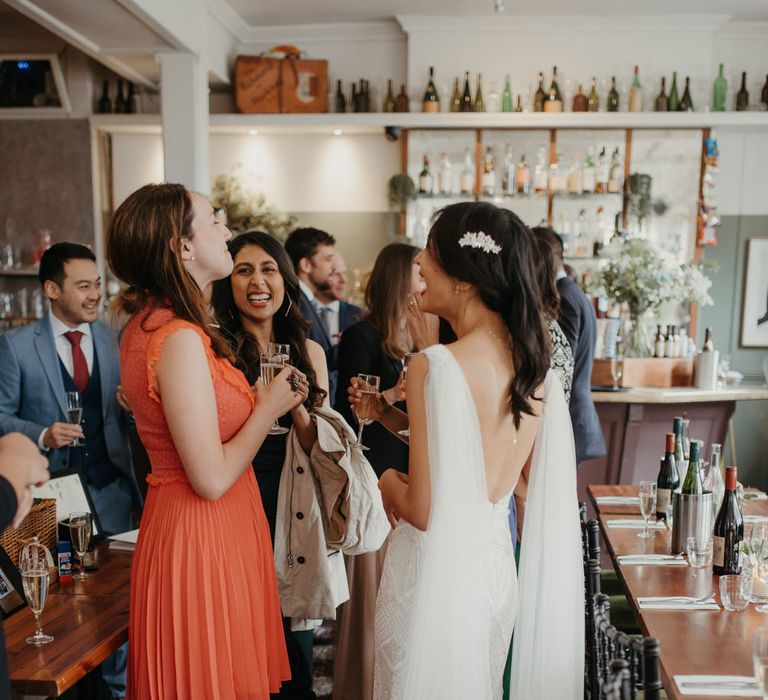 Bride chatting with wedding guests, wearing an Eliza Jane Howell wedding gown