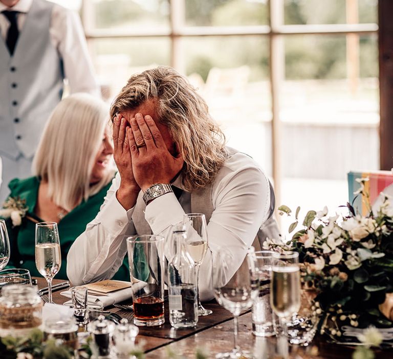 Groom covers his face during wedding speeches