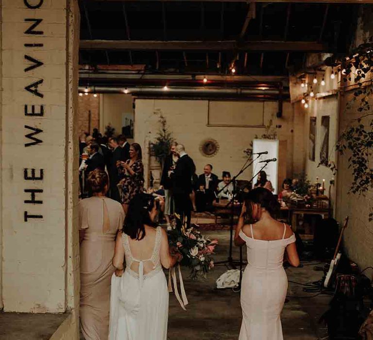 Bride and bridesmaids enter industrial wedding venue