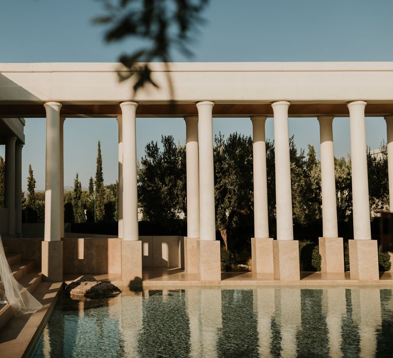 Bride & groom stand next to pool on their wedding day as the sun shines on them | Hannah MacGregor Photo & Film