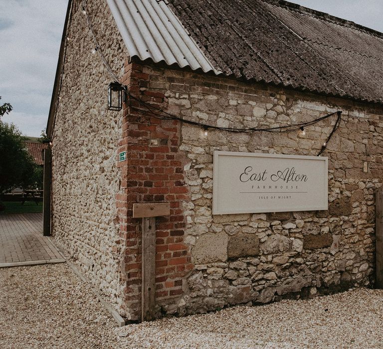 Sign on side of stone barn reading 'East Afton Farmhouse Isle of Wight' 