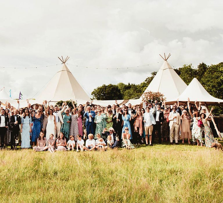 Wedding party outdoors in front of tipis on wedding day