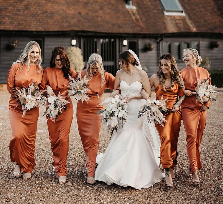 Burnt orange bridesmaid dresses at rustic barn wedding