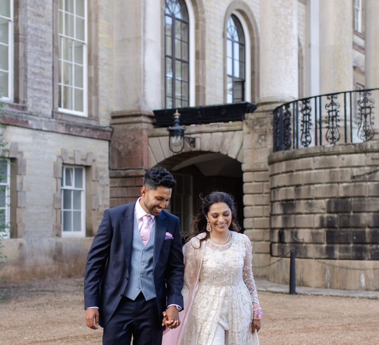 Bride & groom walk with one another outside Ragley Hall