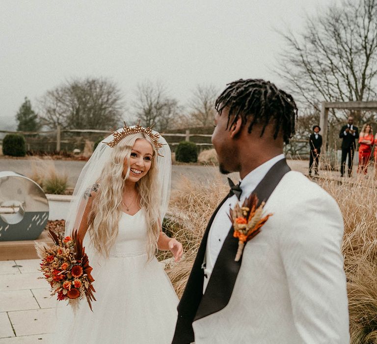 Bride and groom at black tie wedding with orange flowers