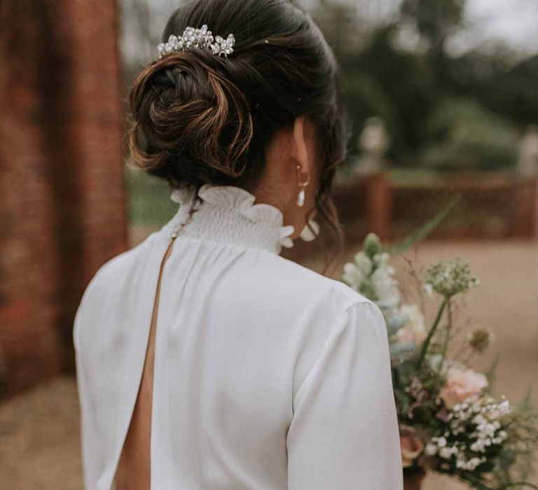 Exposed back on Vanessa Cocchiaro short wedding dress, silver-jewelled hair clip, neutral floral bouquet 