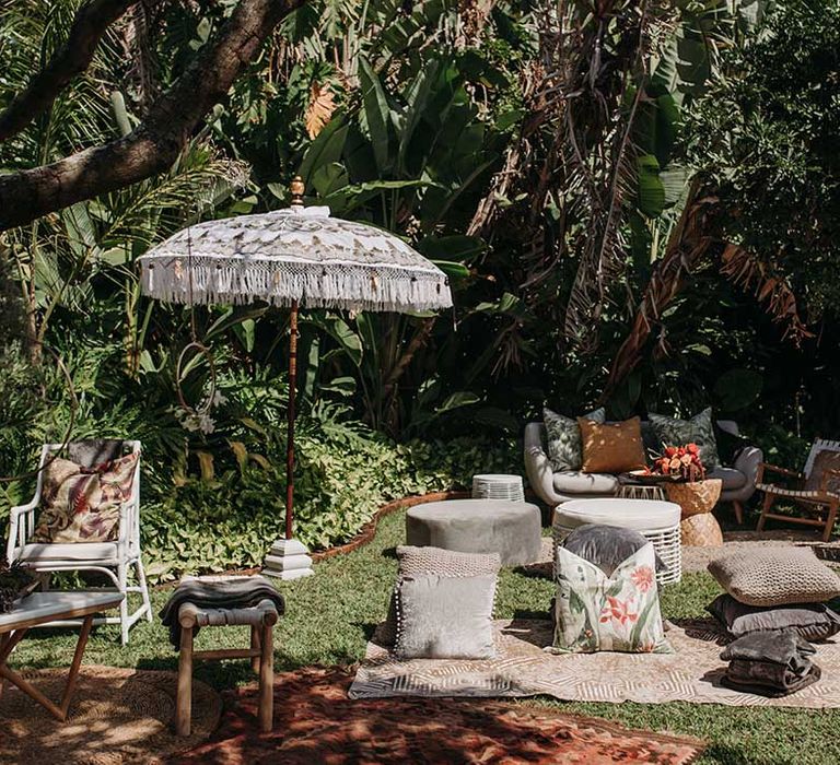 Outdoor wedding seating area for wedding guests with pillows, sofas, beanbags, umbrellas and blankets 