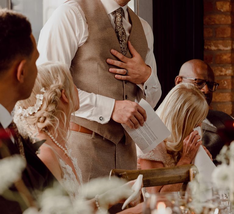 Father of the bride in beige waistcoat gives a speech at daughter's wedding