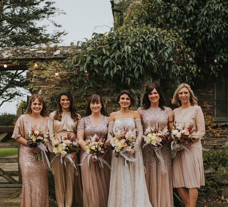 Bridesmaids in various styles of sparkly pink dresses with delicate details 