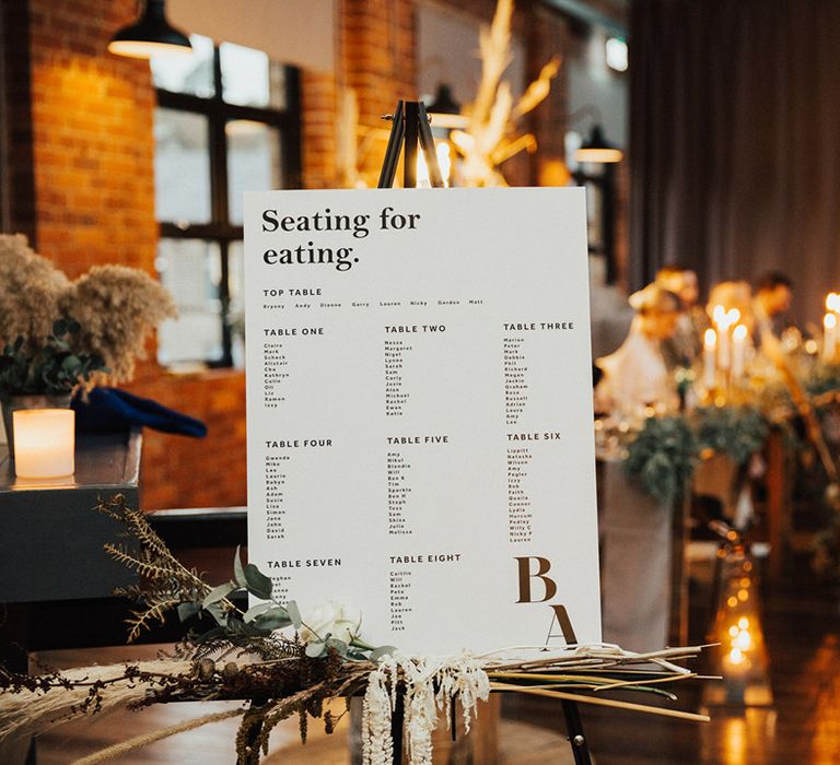 White stationery with modern vibe on wooden easel complete with dried foliage decor