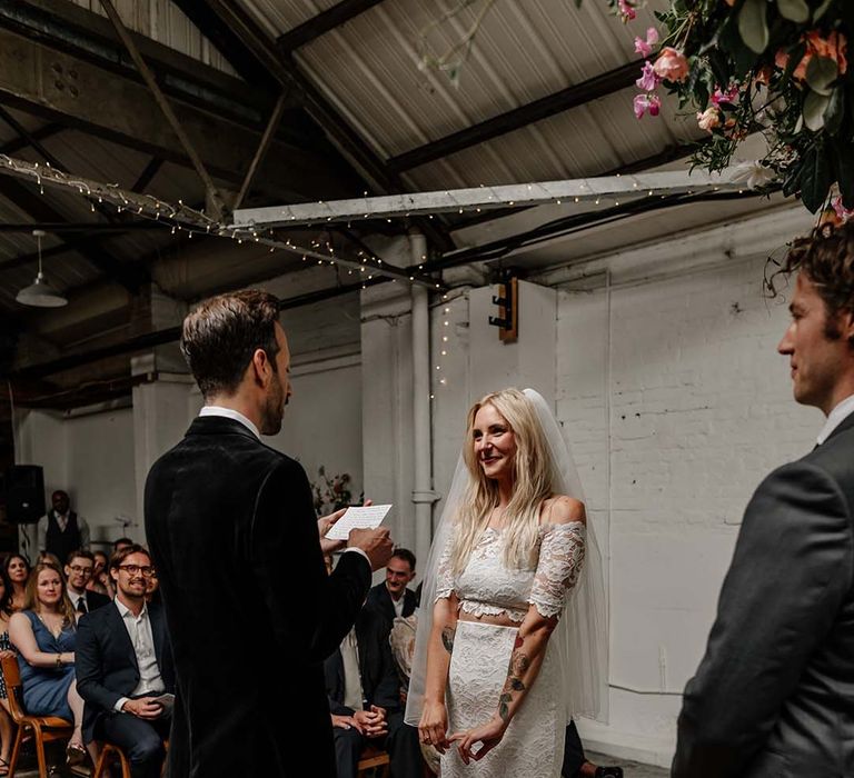 Bride in lace boho two piece with tattoos and groom in black tux with bow tie and boutonniere