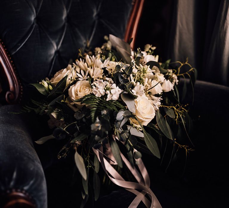 White flower wedding bouquet tied with light pink ribbon 