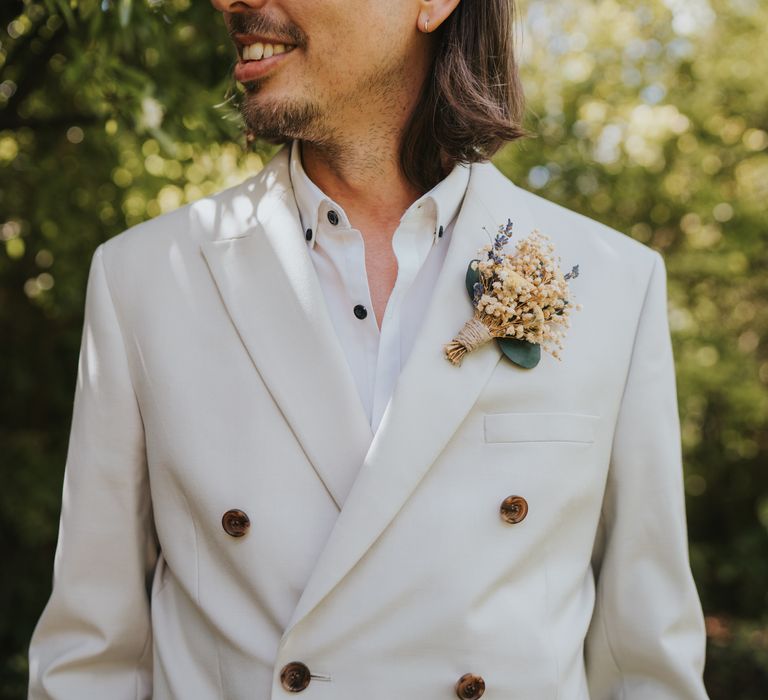 Groom in neutral coloured double-breasted blazer from ASOS and dried flower and foliage boutonniere 