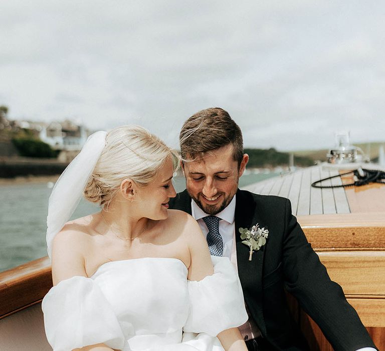 Bride & groom sit with one another during boat ride for Salcombe wedding 