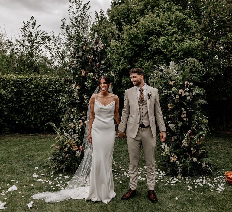 Outdoor wedding ceremony with natural wildflower style wedding column flowers 