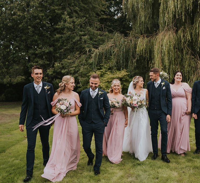 The wedding party for the Dove Barn Wedding with the bridesmaids in pink matching bridesmaid dresses and the groomsmen in navy suits 