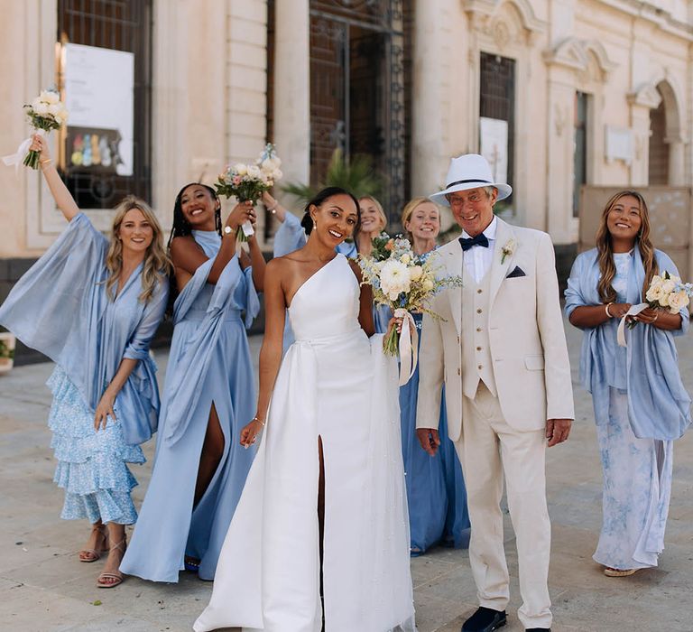 bridal party in blue bridesmaid dresses and a Jane Hill bridal gown