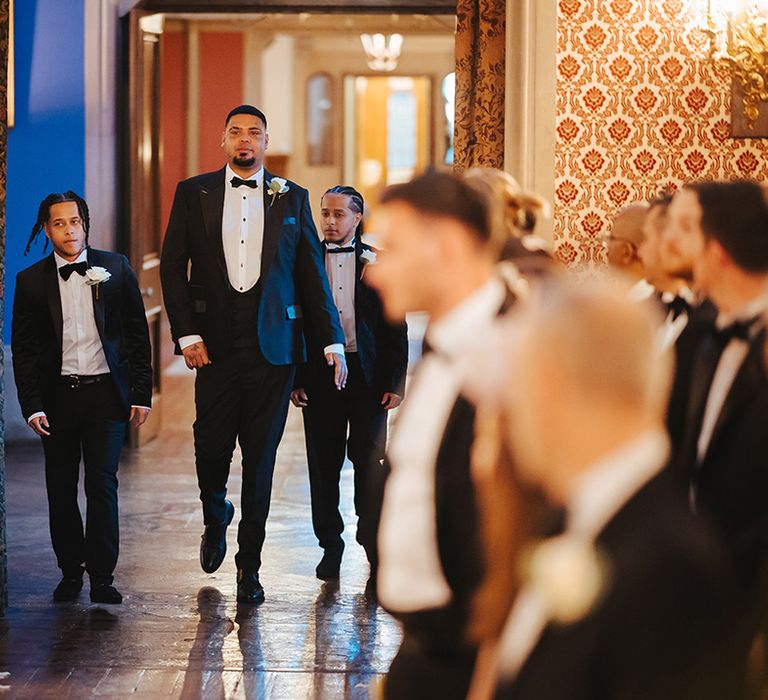 Bridal party wearing classic black tuxedos at black-tie lesbian wedding at Grittleton House