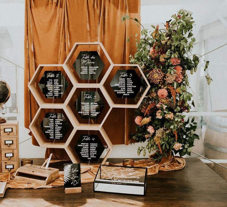 hexagonal wedding seating chart, colour flowers, drapes and wedding guest book