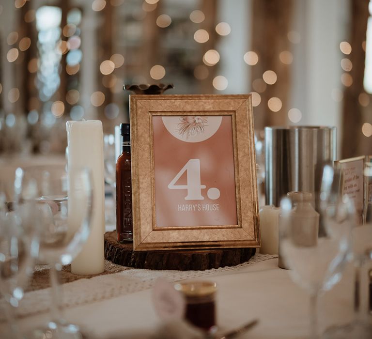 Table name and number sign in gold photo frame designed to match the terracotta colour scheme 