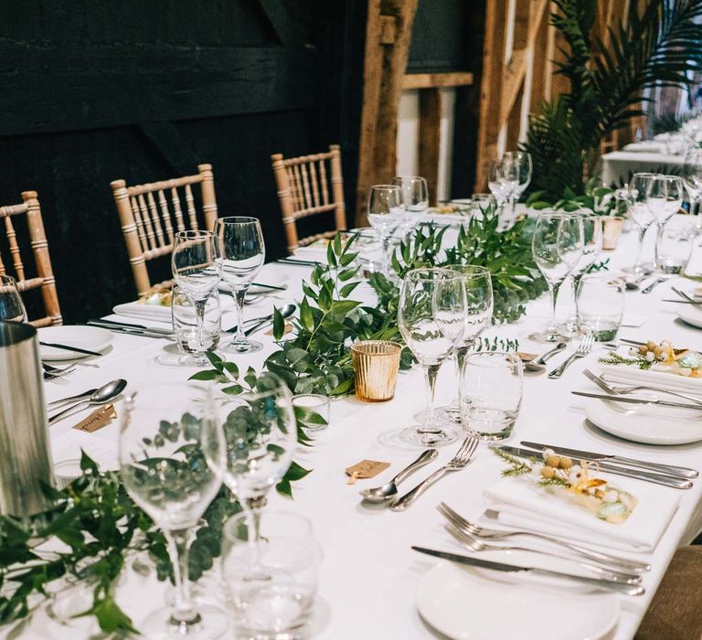 South Farm wedding reception room with classic rustic wedding tablescape - white tablecloth, foliage wedding table runners and gold candle holders