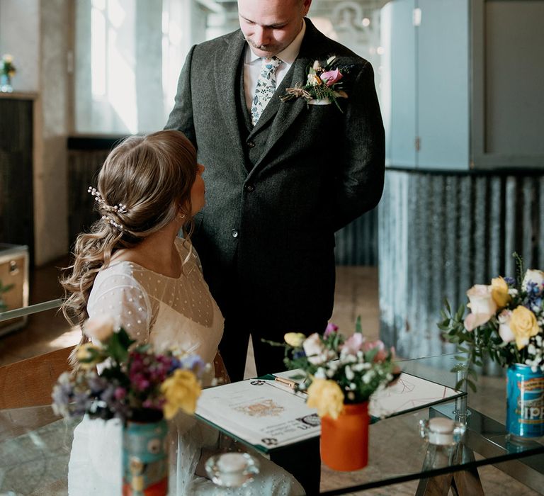 Bride and groom are surrounded by colourful flower arrangements for their spring wedding in Lancashire 