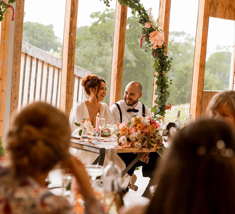 Floral moongate backdrop behind the sweetheart table for the bride and groom 