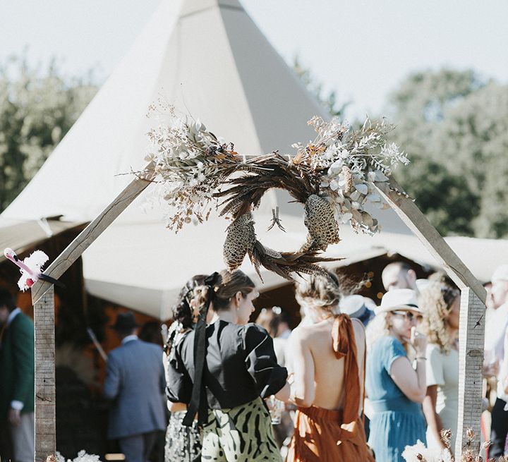 Tipi wedding venue with feather and animal boho decor and dried flowers at entrance