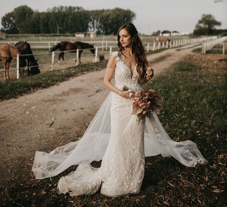 boho bride in an appliqué wedding dress at riding school wedding in Italy 