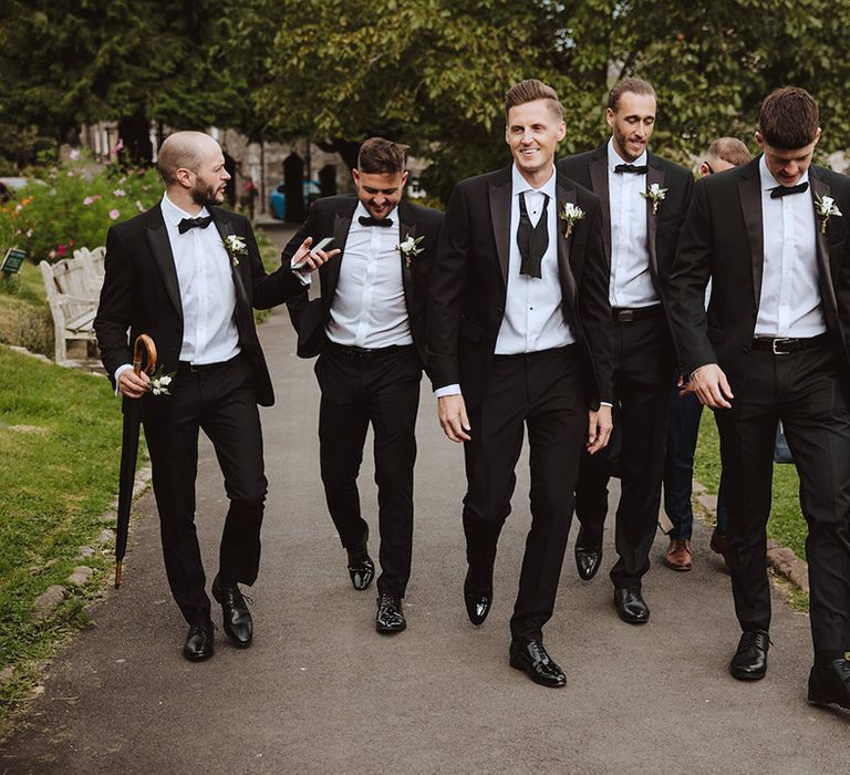 Groomsmen in black tuxedos for traditional wedding 