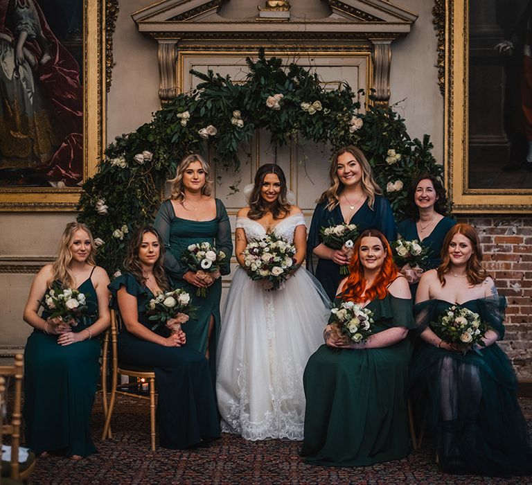 Bridal party wearing emerald green bridesmaid dresses for the Christmas wedding 