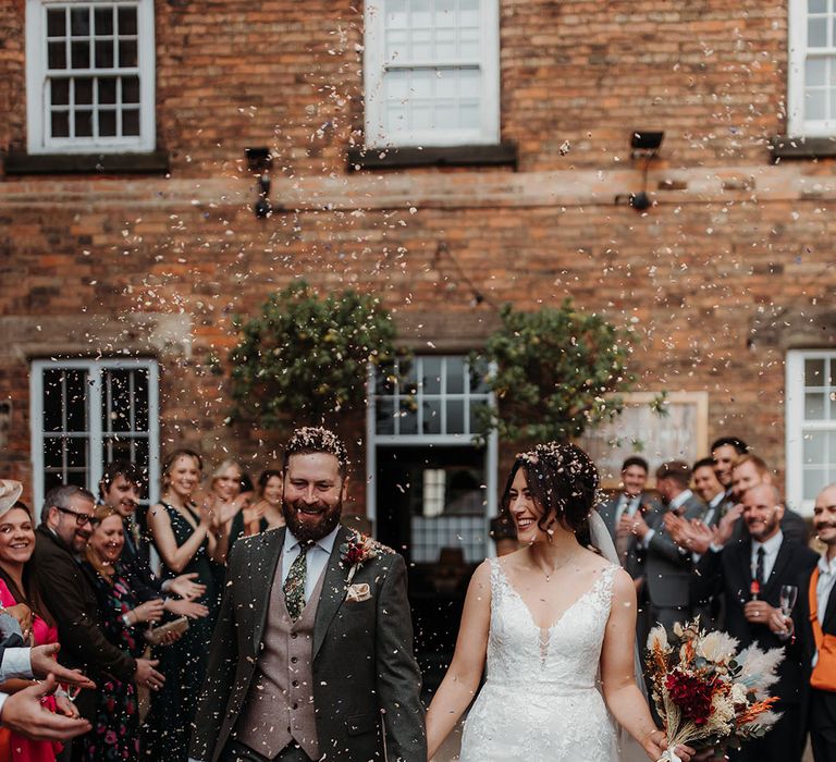 Confetti shot of the bride and groom at their industrial style wedding 