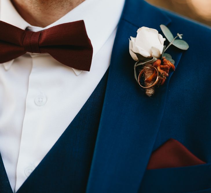 Navy suit and burgundy bow tie