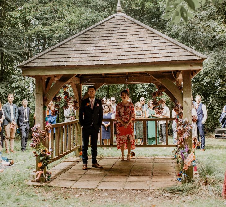 Groom at the altar for outdoor rainbow wedding