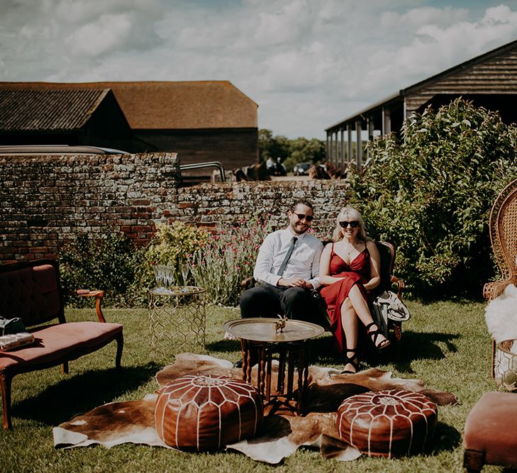 Outdoor seating area with peacock chair, poufs and vintage chairs