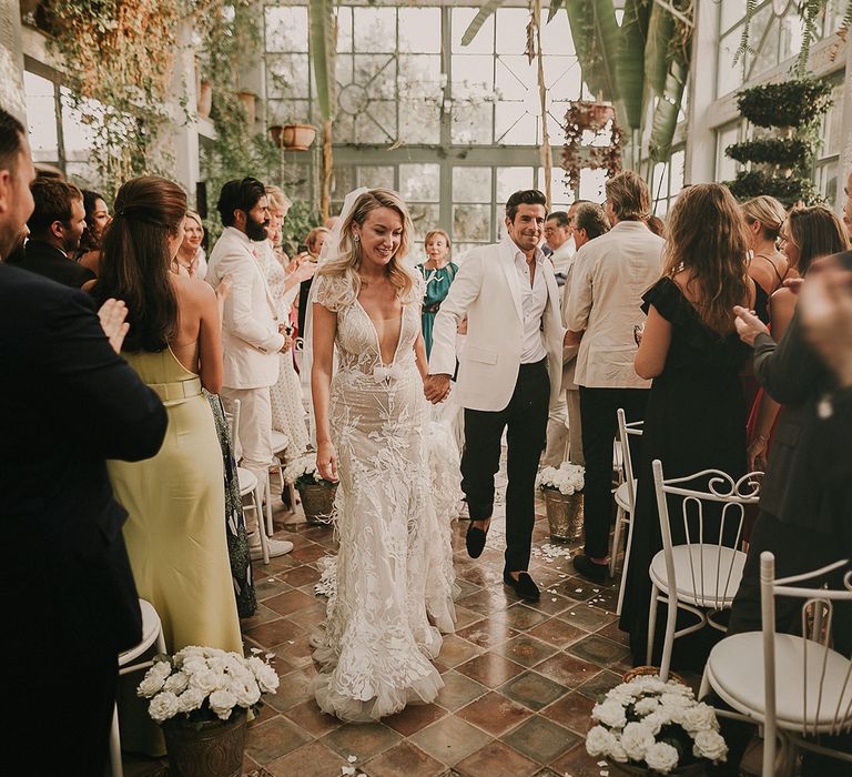 Bride and groom descending down the aisle as husband and wife 