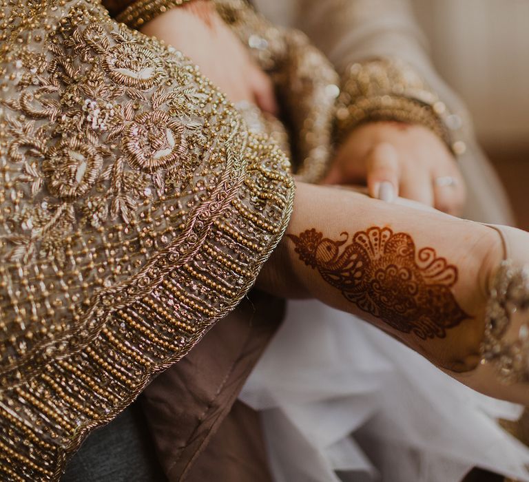 Bride putting on her shoes with henna on her feet 